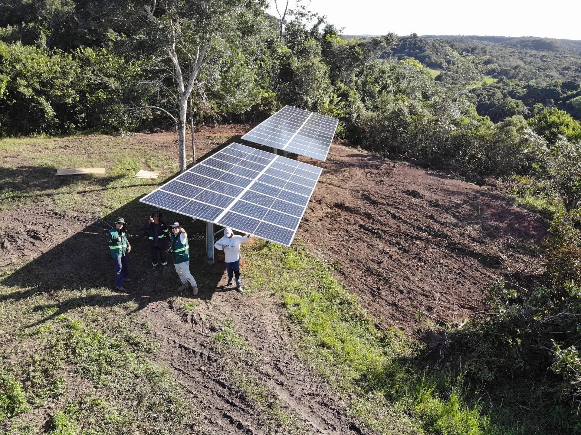 Equipe junto aos módulos solares — registro de campo.